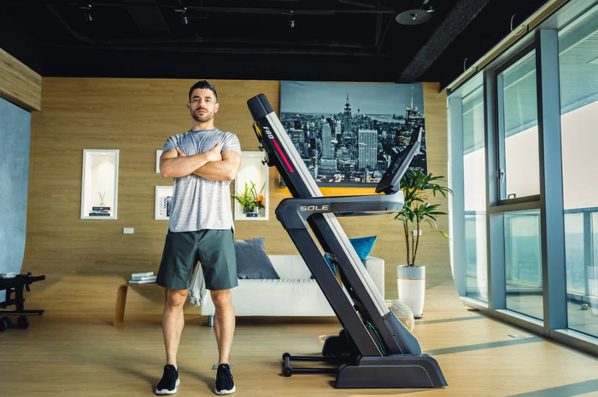 SOLE F80 treadmill shown at home, highlighting its compact folding footprint and touchscreen console for everyday runners