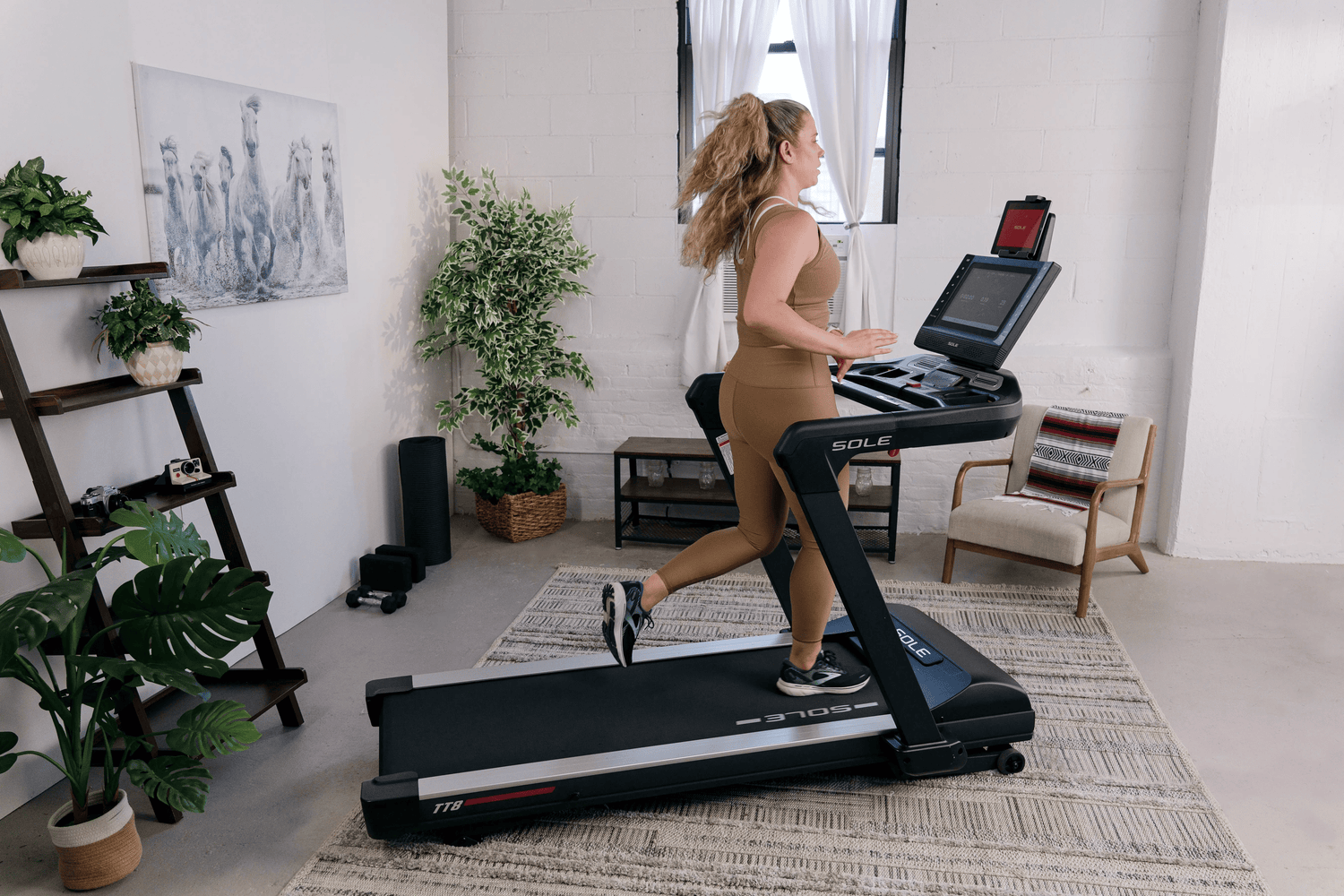 Woman using the SOLE TT8 Treadmill in a living room.