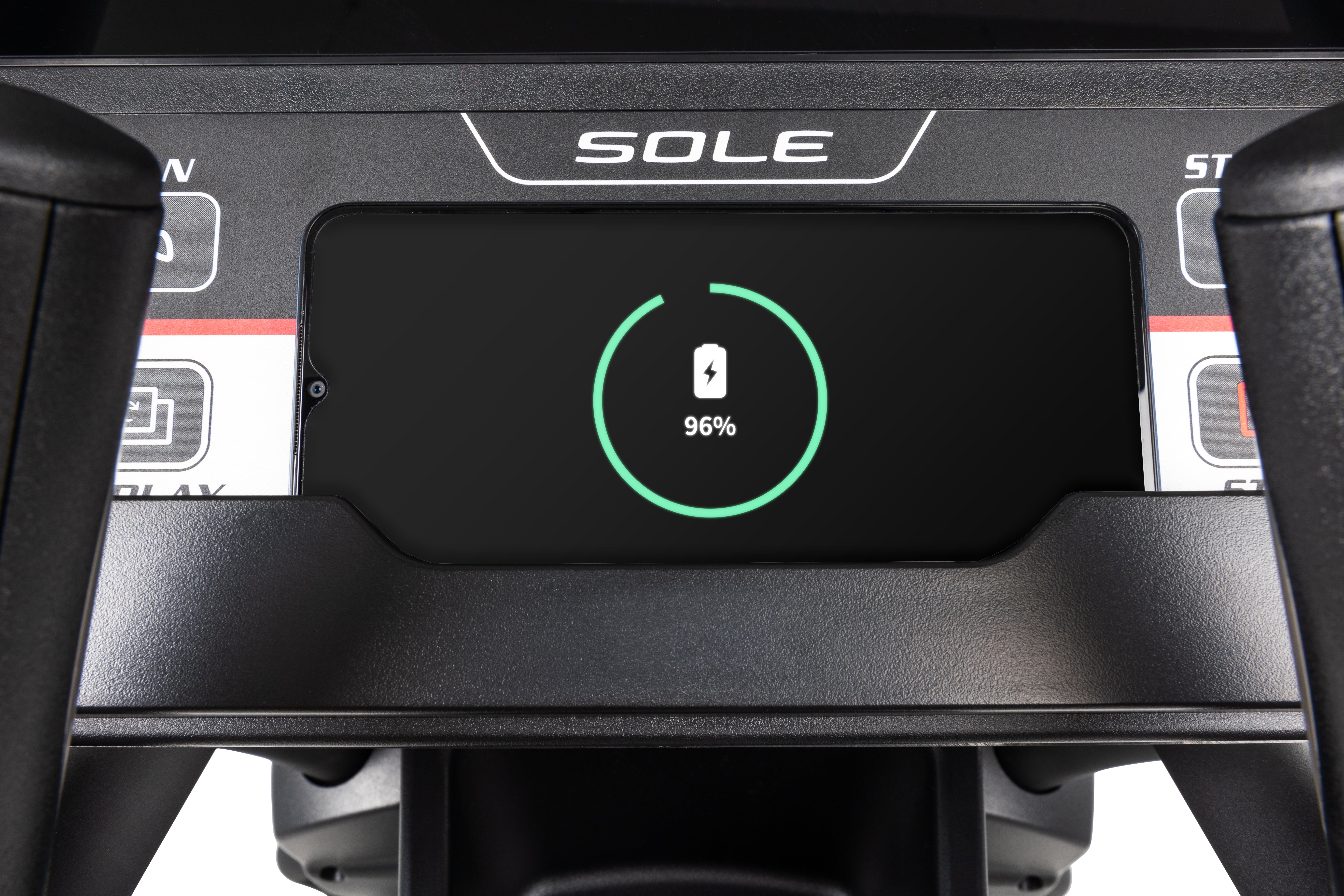 The Sole E95S charging pad with a phone charging.