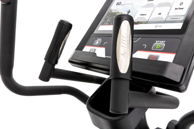 Detailed view of the Sole E98 elliptical machine's handle with built-in heart rate monitors in chrome accents, touchscreen display showcasing fitness metrics, and control buttons, including the illuminated "SOLE" logo and start button, against a white background.