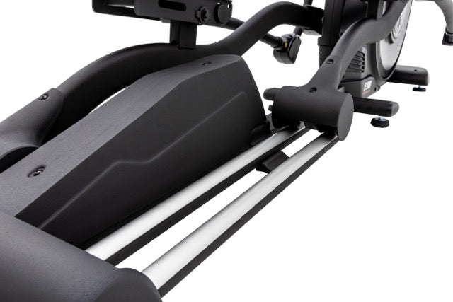 Close-up side view of the Sole E98 elliptical machine, highlighting the sleek grey body, adjustable foot pedals, white rails, and control knobs against a white background.