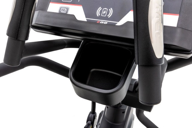 Close-up view of the Sole E98 elliptical machine's console area, showcasing the digital display with E98 and connectivity symbols, a storage compartment beneath, and cushioned handle grips, set against a white background.