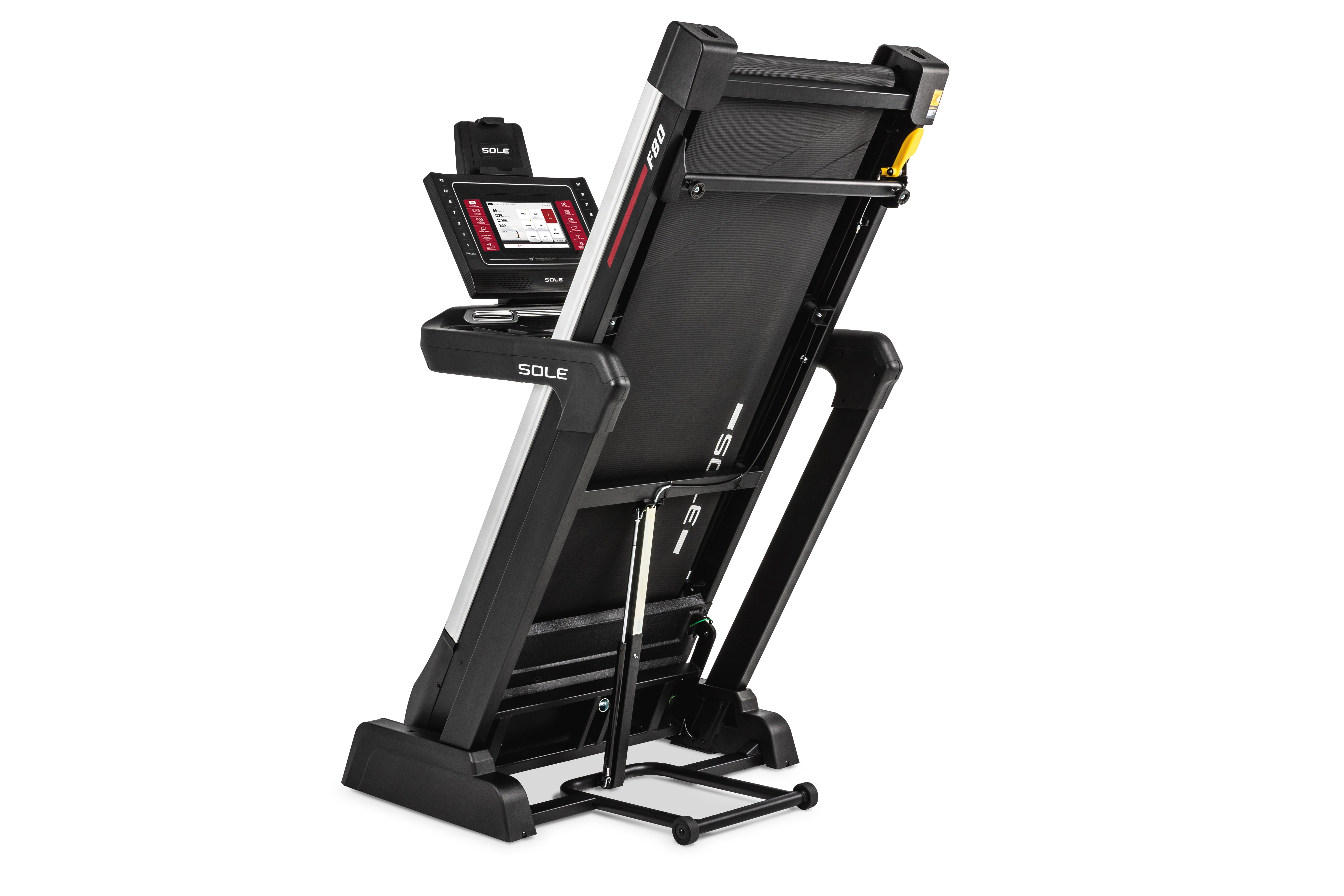 Side view of the Sole F80 treadmill in a folded position, featuring its digital touchscreen console, tablet holder, "F80" branding on the frame, and a secure yellow safety latch for storage.