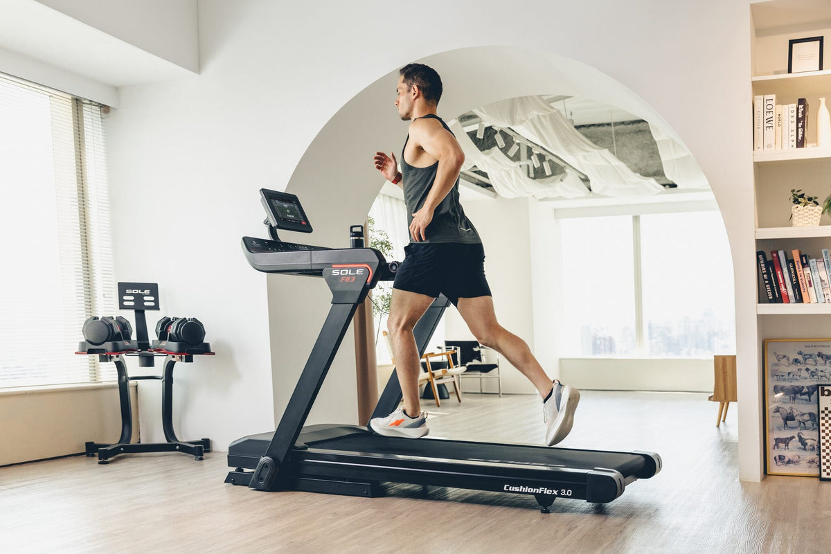 A man running on a SOLE Fitness F83 treadmill while it tracks his distance