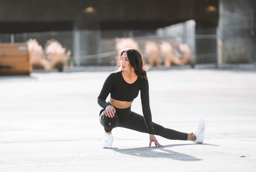 A young woman in exercise clothes stretching