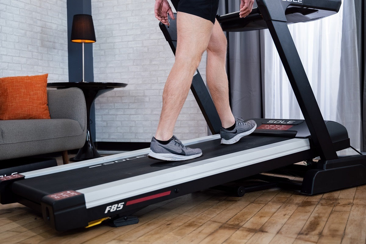 Close-up of a person walking on an inclined SOLE treadmill at home
