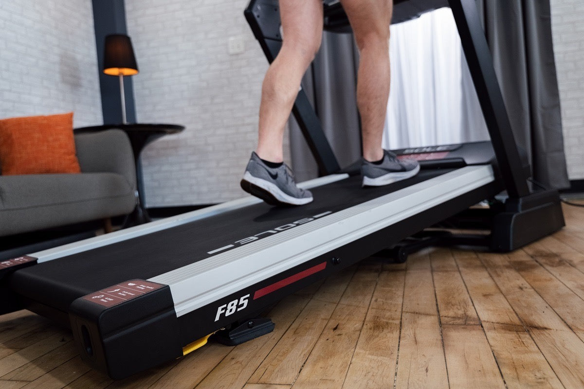 Close view of a SOLE F85 treadmill deck and belt with a person walking on it