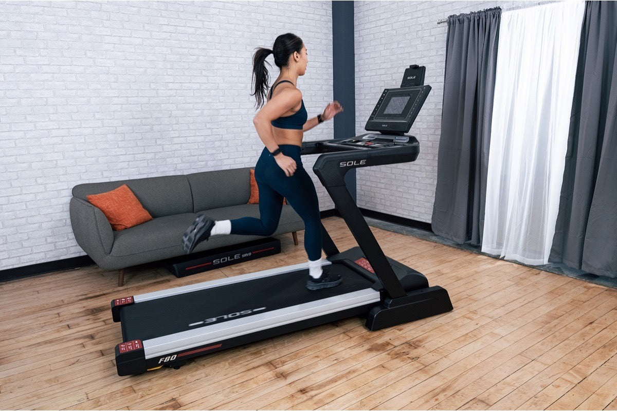 Woman running on a SOLE F80 treadmill during a home session