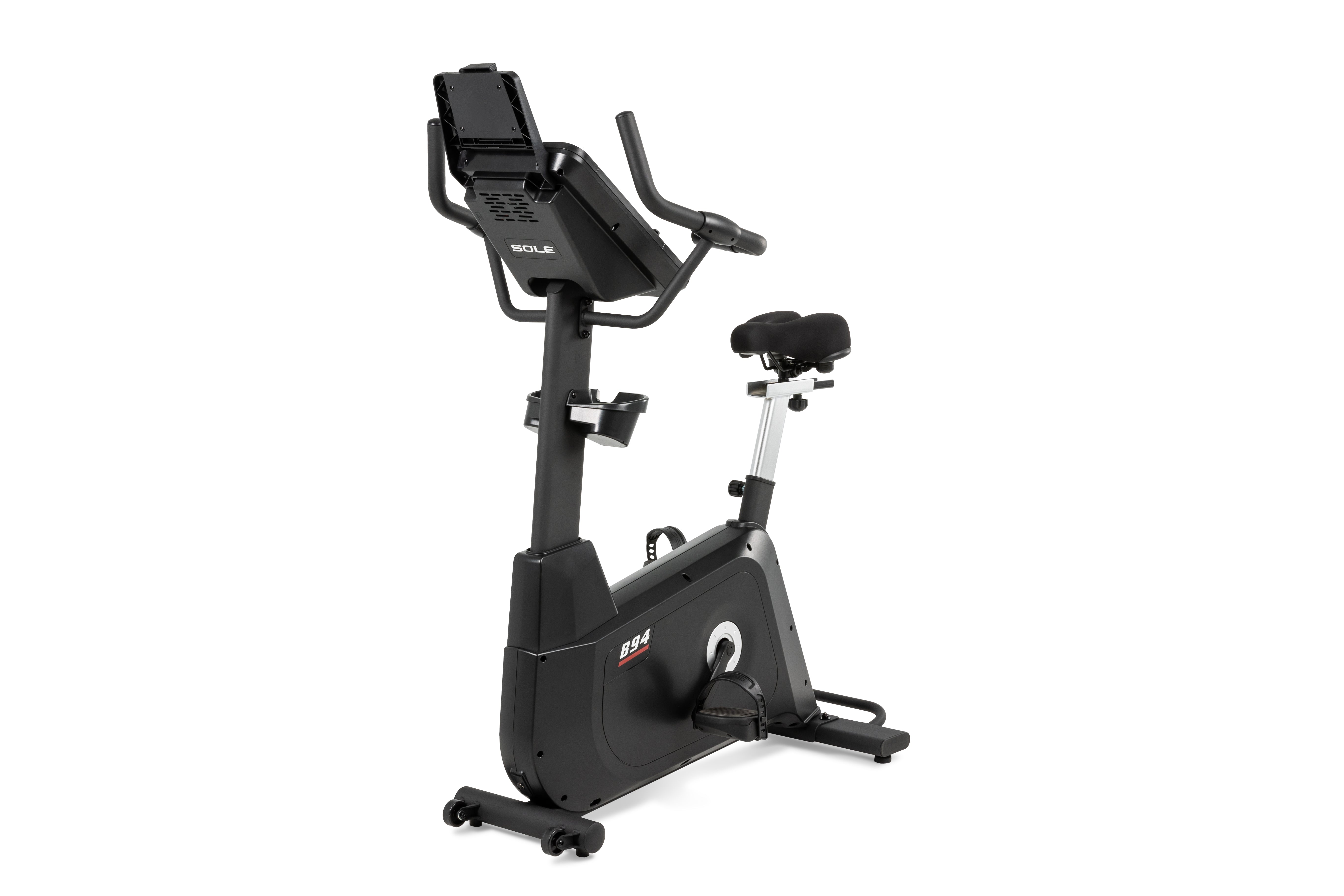 Sole B94 upright exercise bike featuring a digital display console, ergonomic handlebars, adjustable black seat, and a sleek dark frame on rolling wheels.