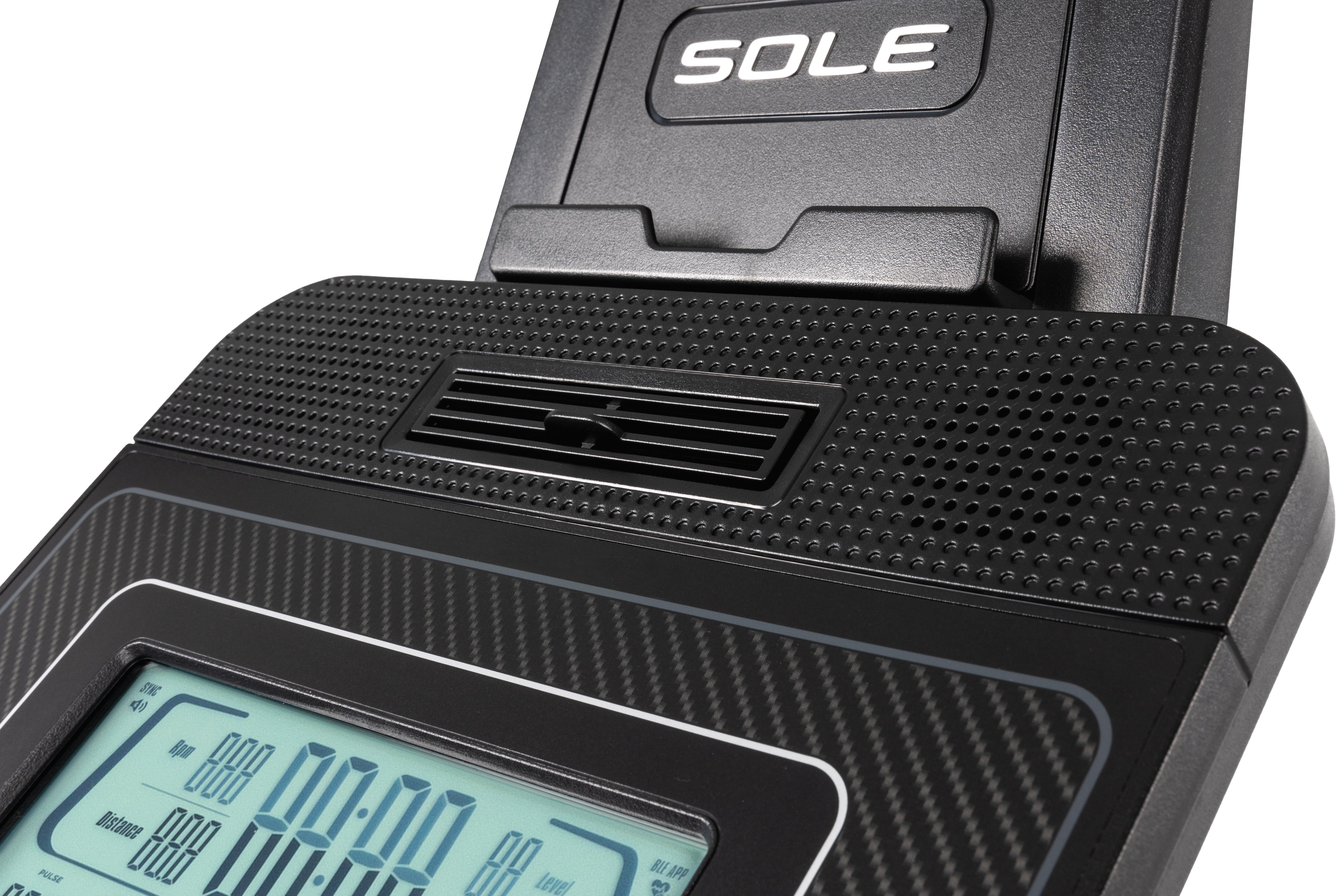 Close-up of the Sole B94 exercise bike's console, featuring the embossed 'SOLE' branding, a textured surface, a ventilation slot, and a digital display showing workout metrics.