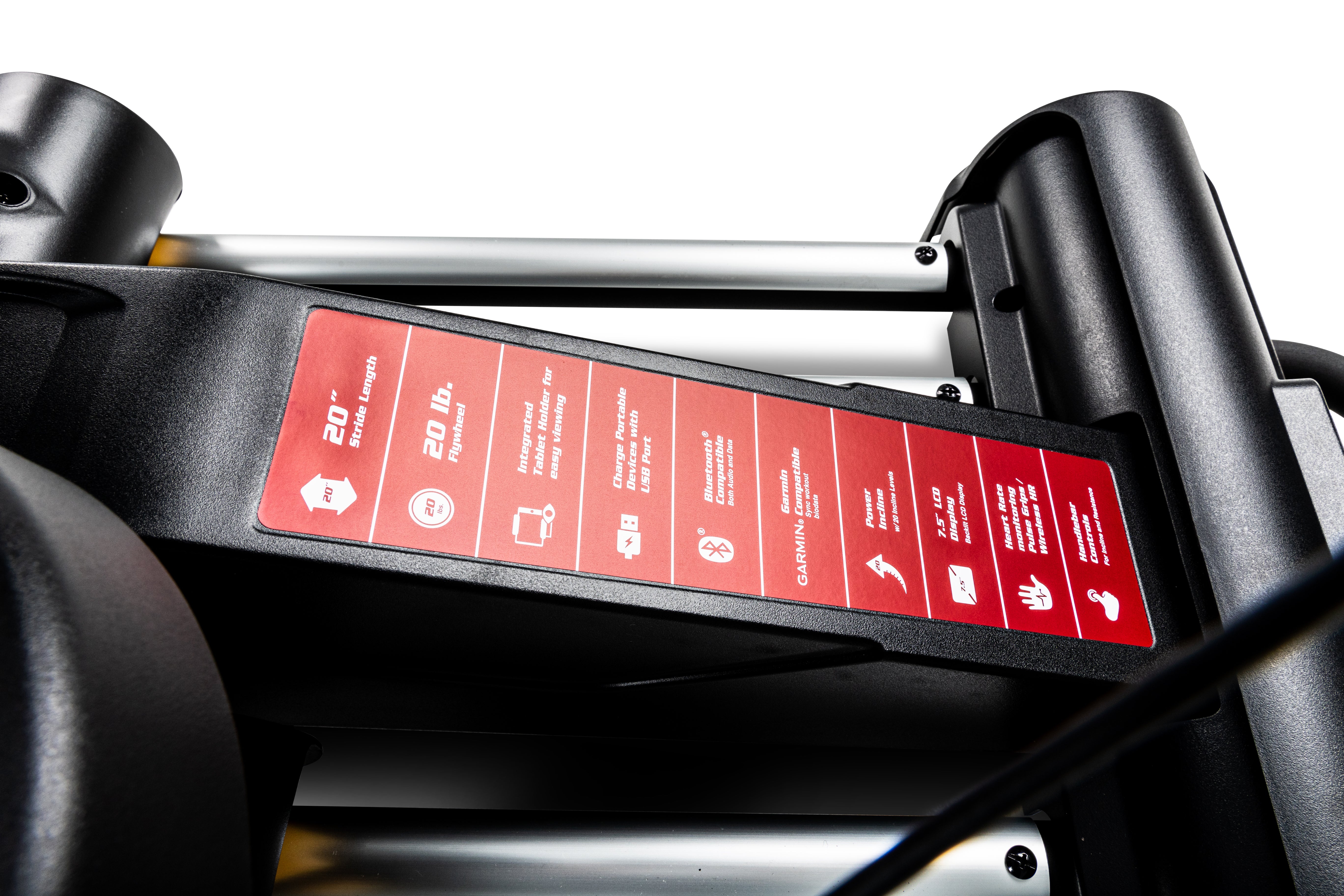 Close-up of the Sole E25 elliptical's red instruction sticker, detailing various operational guidelines and icons, affixed to its black frame near joint connectors.
