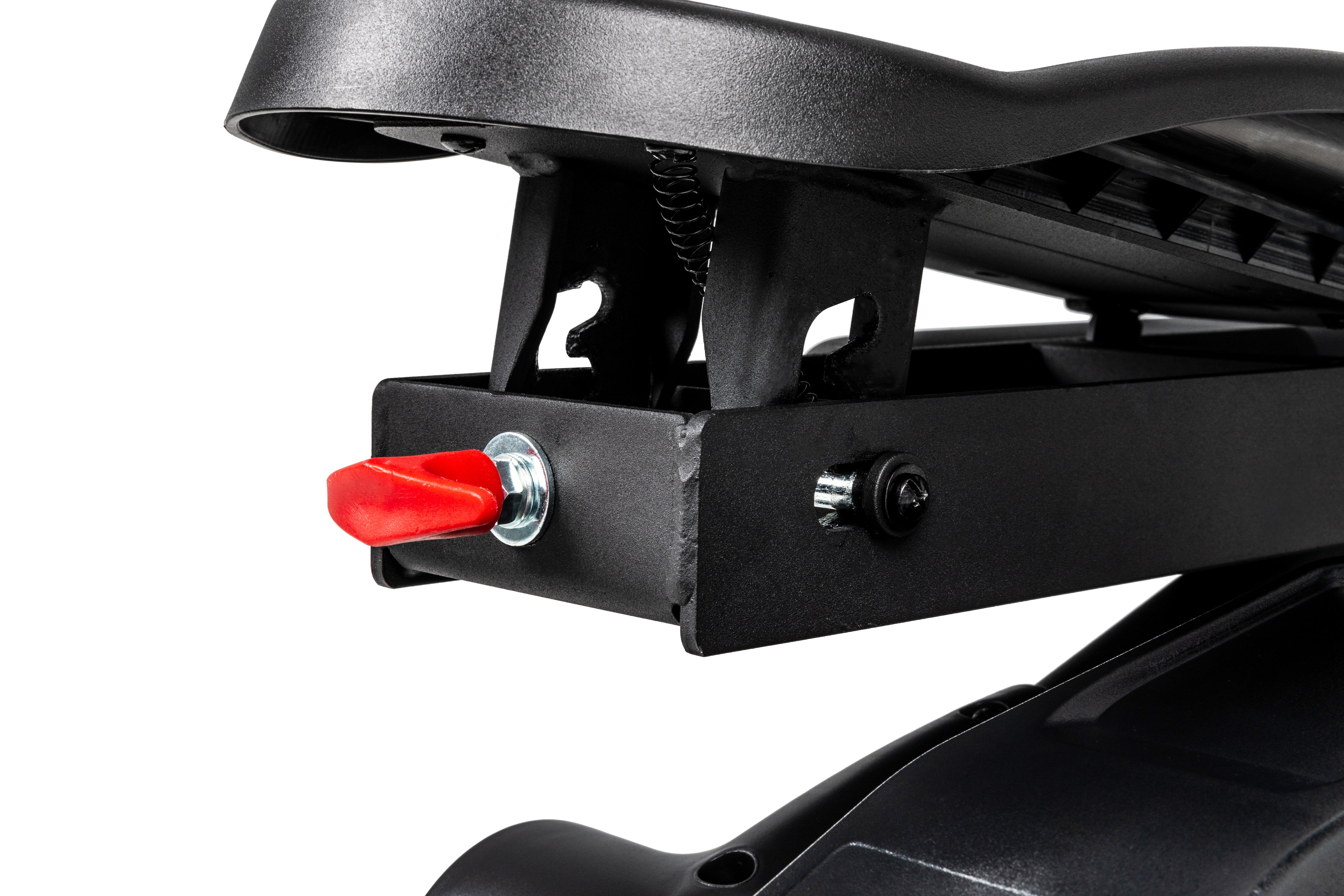 Detailed view of the Sole E35 elliptical trainer's pedal mechanism, showcasing a red adjustment knob, spring, and various bolts.