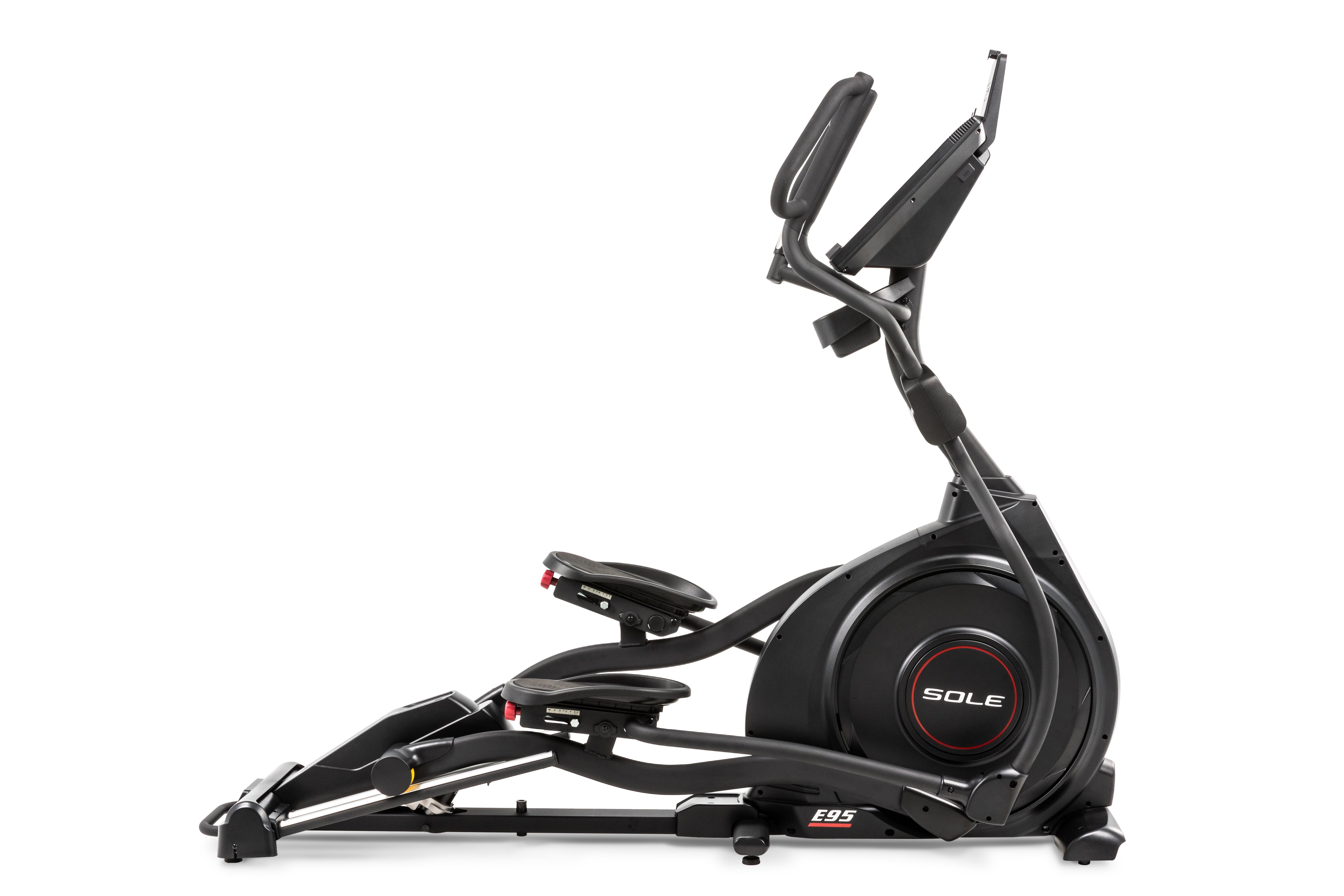 Side view of the Sole E95 elliptical machine, showcasing its sleek black design with a large flywheel housing branded 'SOLE'. The machine features adjustable foot pedals with red dials, dual handlebars with integrated controls, and an elevated console displaying workout metrics.