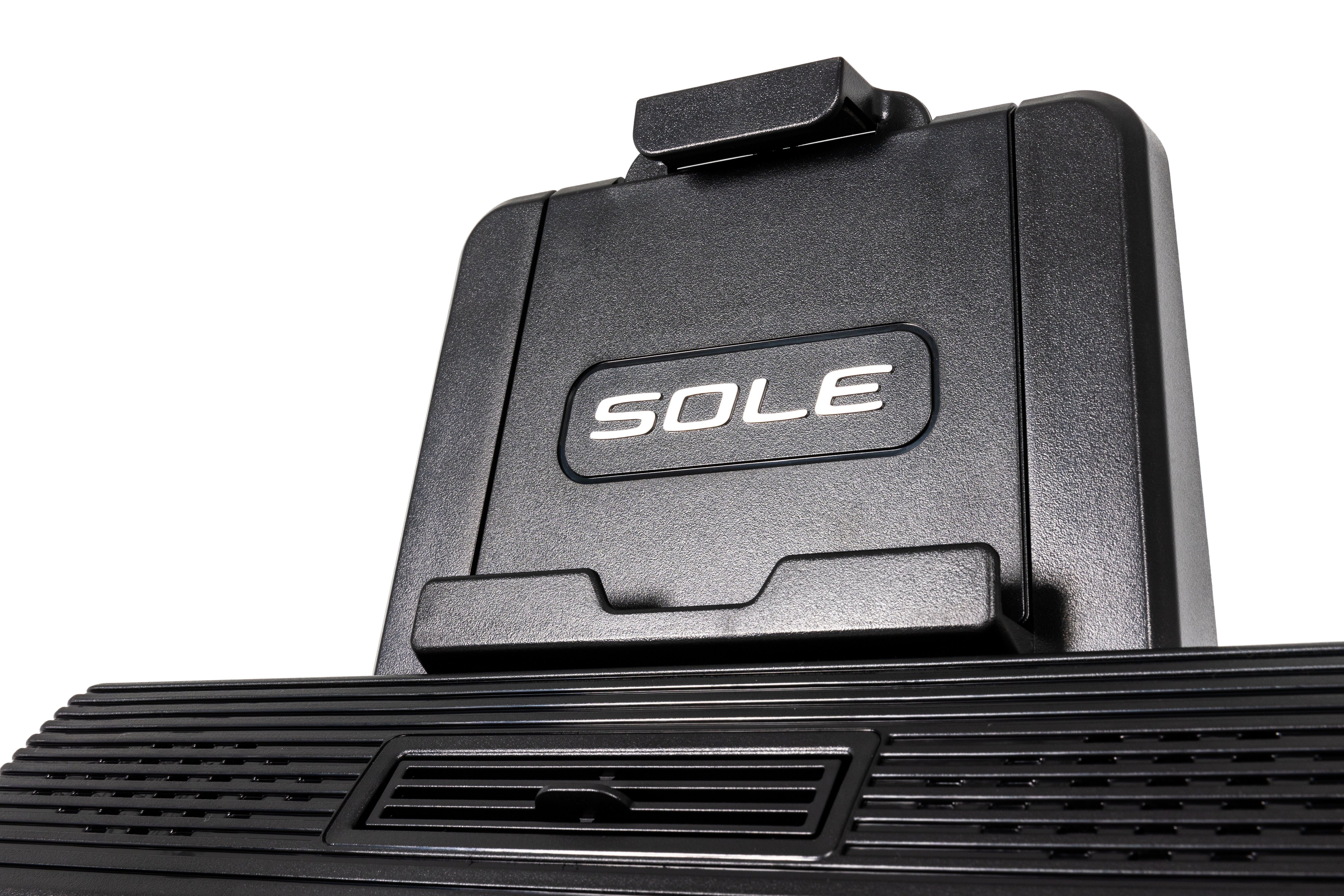 Close-up of the upper section of the Sole E95 elliptical trainer, showcasing its textured black finish, the embossed 'SOLE' logo, and a detailed view of the foot pedal's ribbed surface and ventilation slots.