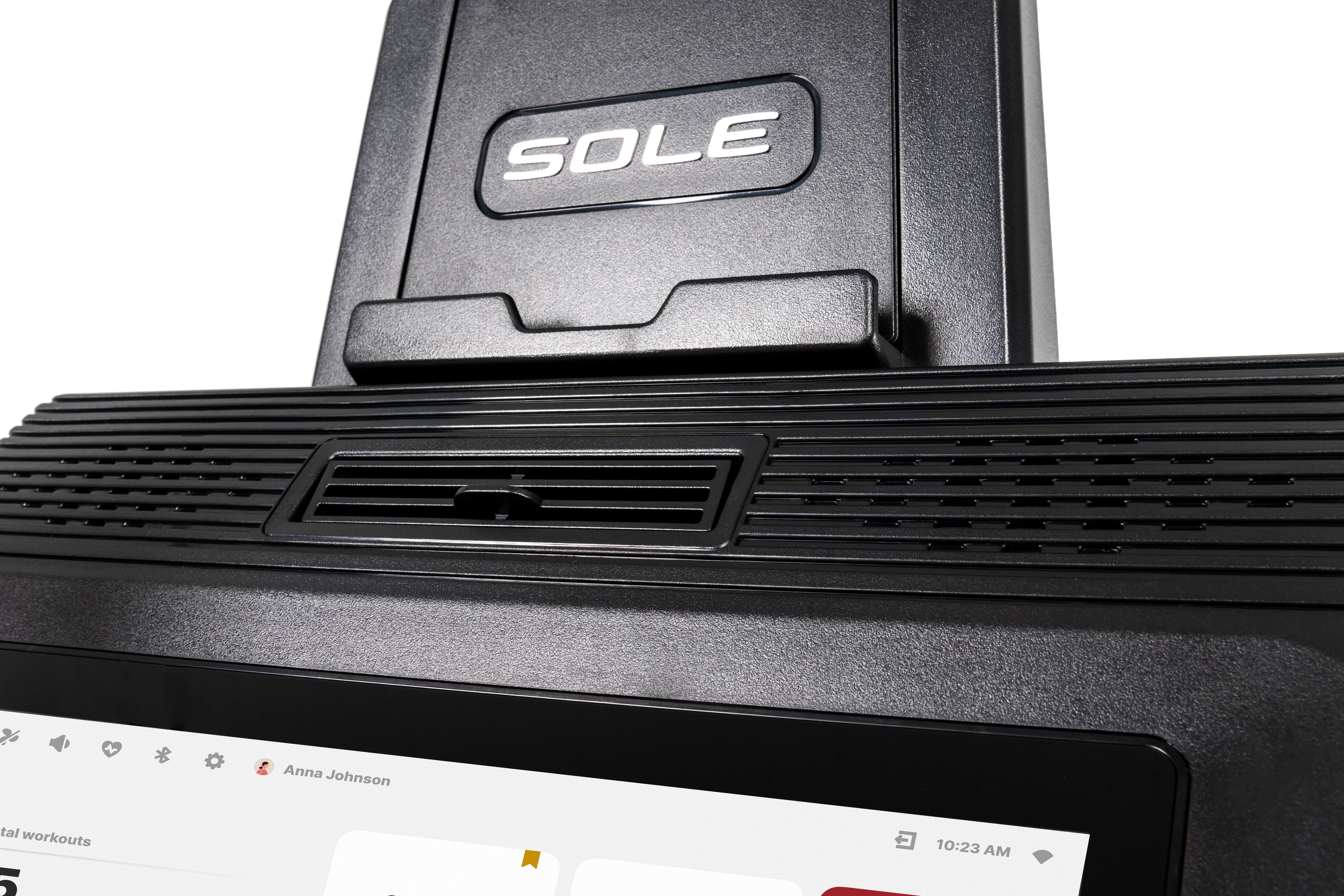 Close-up view of the Sole E95S elliptical machine's base, featuring the embossed "SOLE" logo, textured design, and a portion of the digital display with a user profile named "Anna Johnson" visible at the bottom.