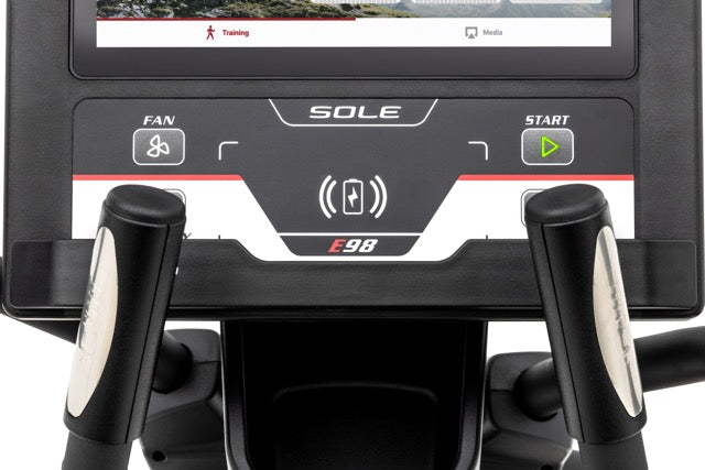Front view of the Sole E98 elliptical machine's console displaying "Training" and "Media" on its screen, with control buttons labeled "FAN", "SOLE", "E98", and a green "START" button. The console is flanked by two black handles, each with a chrome accent.