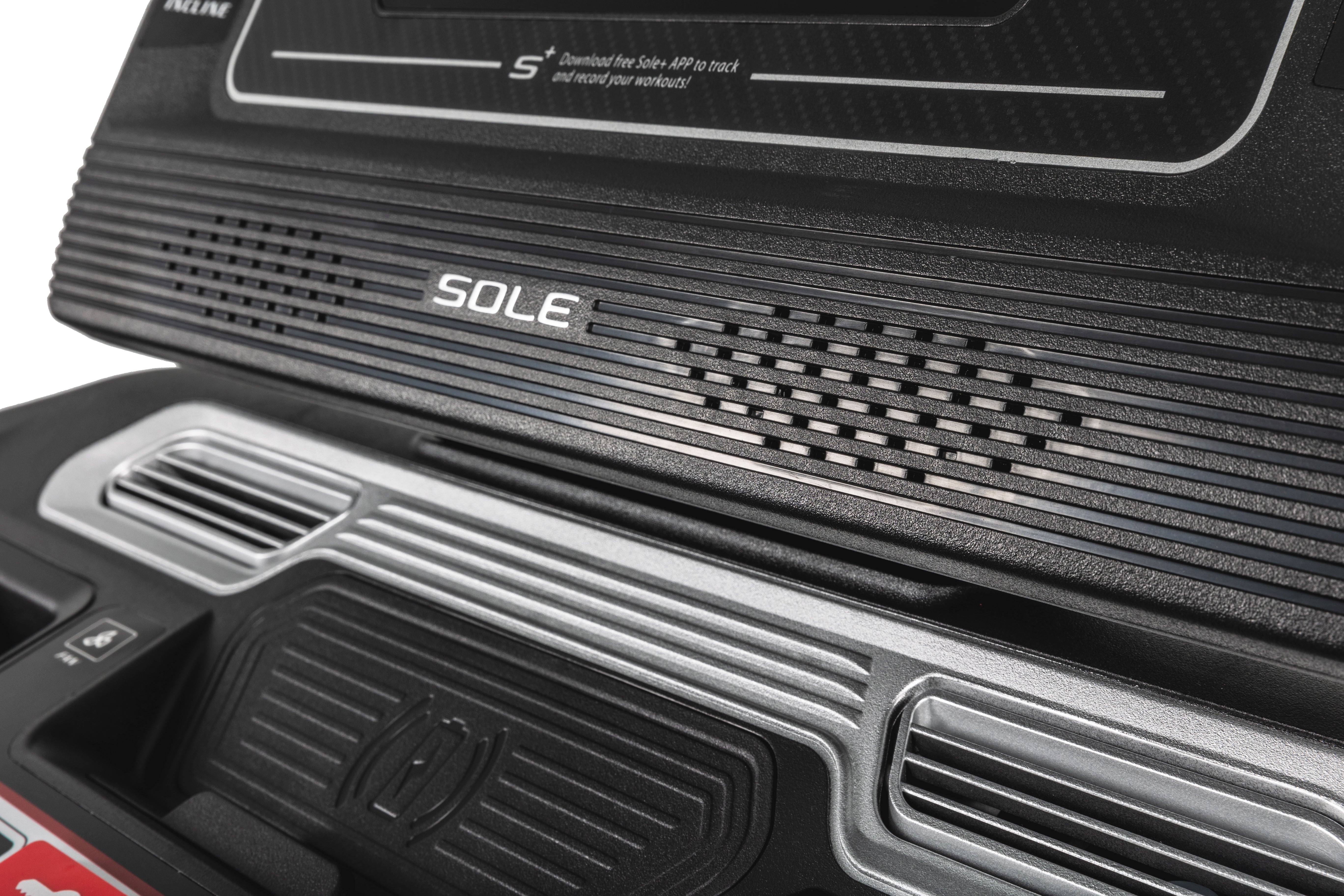 Detail shot of the Sole F80 treadmill's front panel, showcasing the textured grip surface, vented area, embossed 'SOLE' logo, and a molded storage compartment with ridged design.