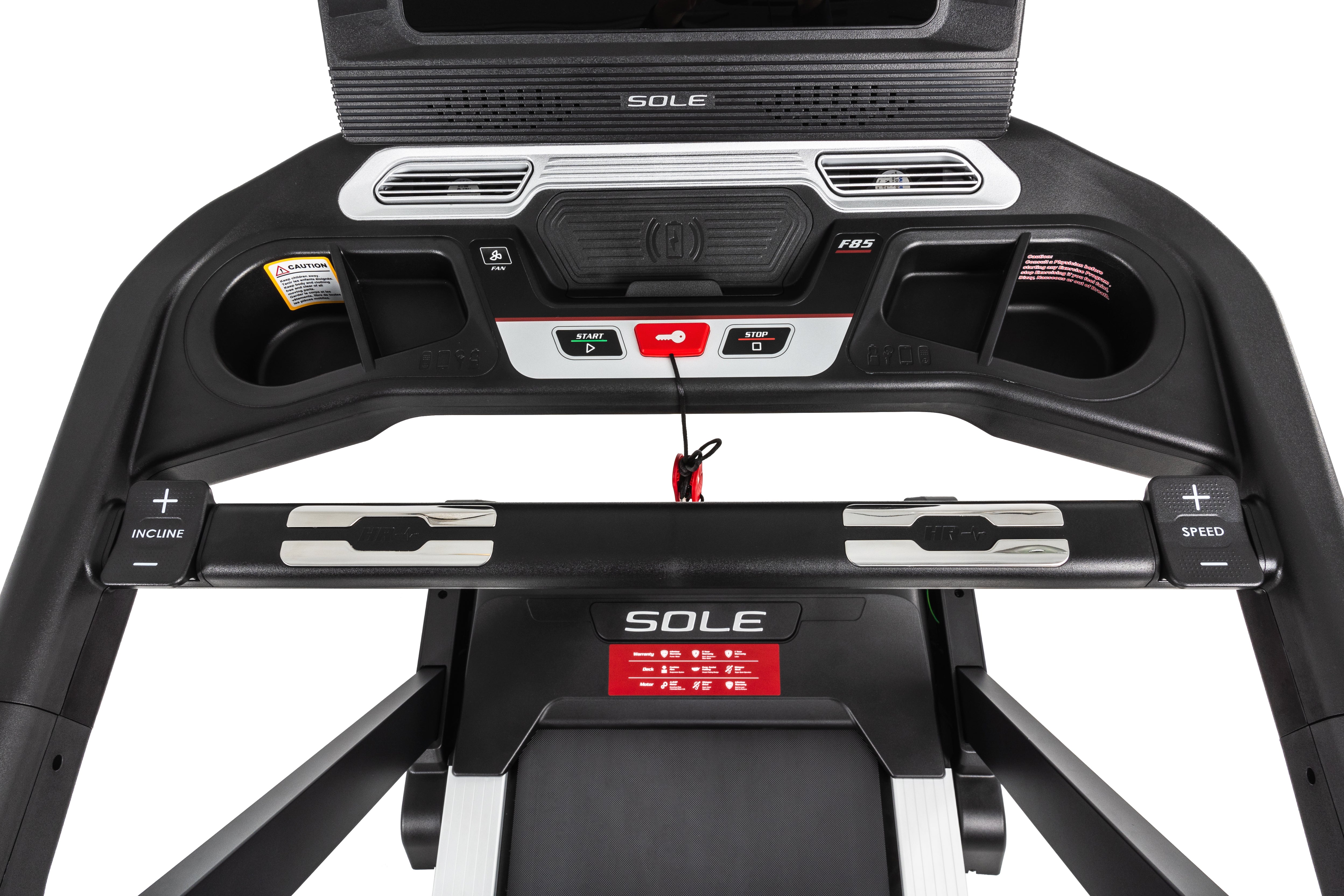 Overhead view of the Sole F85 treadmill console featuring a central digital display with F85 labeling, start and stop buttons, a wireless charging pad with logo, dual cup holders, incline and speed adjustment arms on either side, and the SOLE logo prominently displayed on the lower front panel.