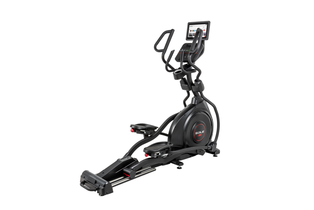 SOLE E95 elliptical shot from above at three-quarters with the 13.3 inch touchscreen lit and turned toward the camera, the ramp running down toward the front stabiliser