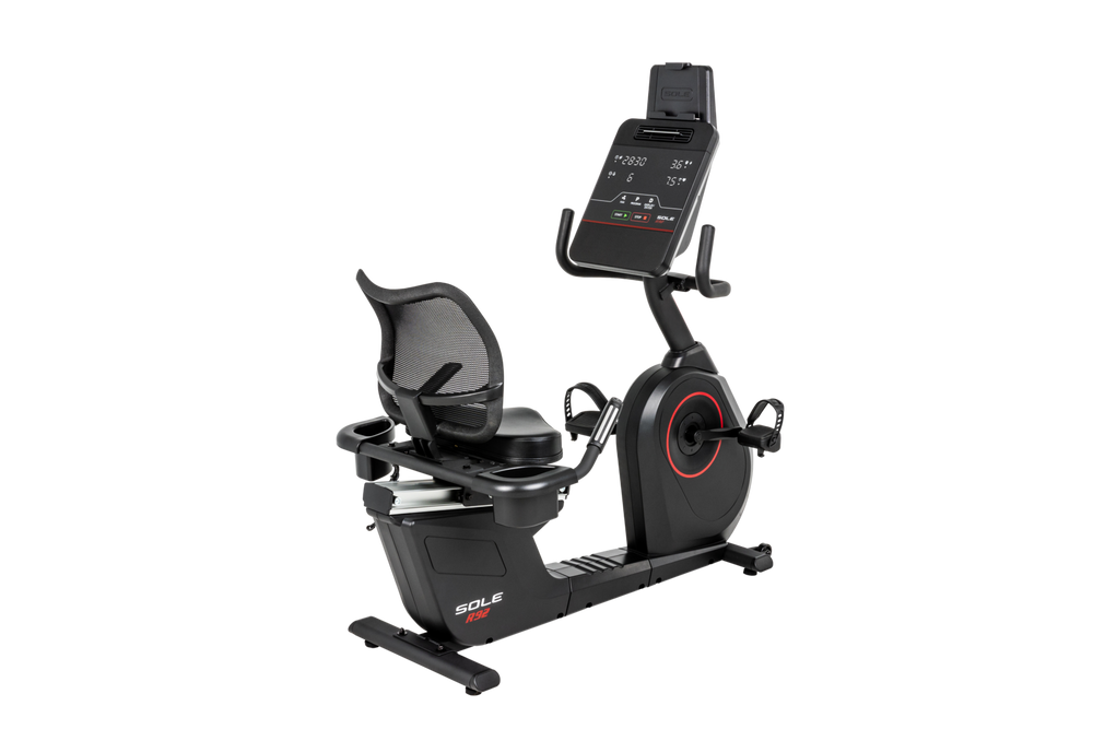 SOLE R92 recumbent bike, three-quarter view with the mesh-back seat on the left and the flywheel housing and LED console on the right