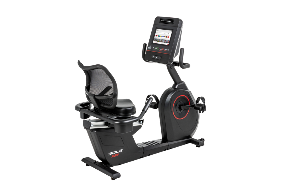 SOLE R98 recumbent bike, three-quarter view with the mesh-back seat on the left and the flywheel housing and touchscreen console on the right