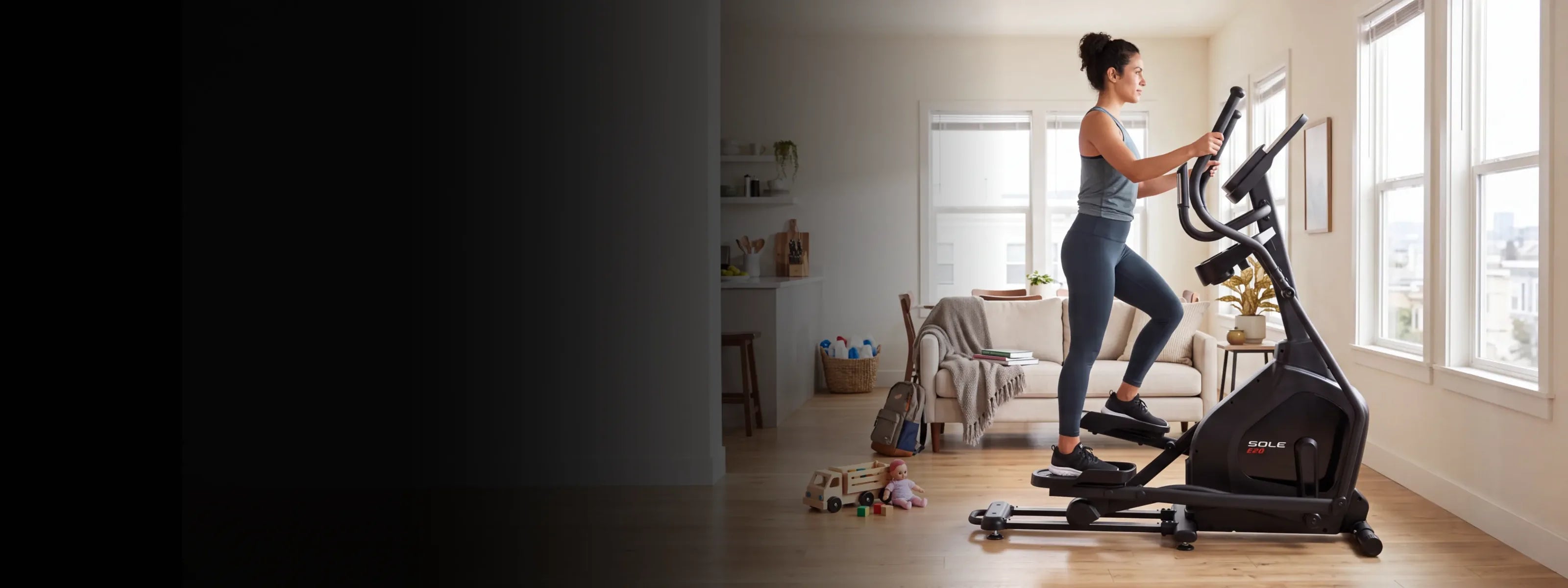 A person exercising on the SOLE E20 elliptical in a sunlit living room